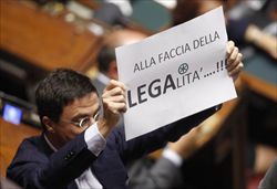 L'esponente di Futuro e Libertà Italo Bocchino alza un cartello contro la Lega alla Camera dei Deputati.