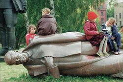 Bambini giocano su una statua abbattuta di Stalin. 