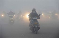Scooter nello smog di Jiaxing, in Cina (foto: Reuters).