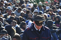 Alcuni stranieri sbarcati sull'isola di Lampedusa in attesa di essere identificati. Foto Ciro Fusco/Ansa.