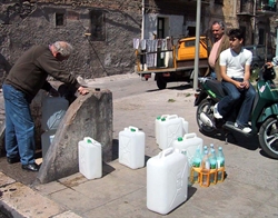Scorta di acqua alla fontana in una borgata di Roma.