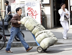 Un uomo cinese al lavoro a Milano, in via Paolo Sarpi