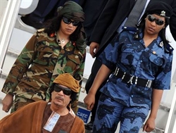 Gheddafi con due delle sue famose guardie del corpo.