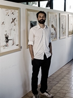 Il pittore e grafico Matteo Zanfi davanti ai suoi quadri (Foto: Ennio Montani).