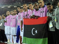 La nazionale della Libia mostra la nuova bandiera (copertina e questa foto: Epa/Ansa).