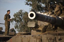 Un soldato israeliano prega sul suo carro armato.