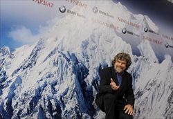 L'alpinista Reinhold Messner davanti a una fotografia gigante del Nanga Parbat, una delle vette più difficili al mondo (foto Corbis).