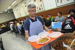  Milano. Un volontario serve pranzo a una mensa per poveri.