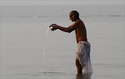 Un pellegrino indù si bagna nelle acque sacre del Gange (foto del servizio: Reuters)..
