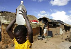 Un bambino trasporta una bottiglia d'acqua a Epworth, un sobborgo di Harare, la capitale dello Zimbabwe.Foto di Philimon Bulawayo/Reuters.
