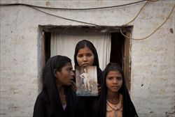Le figlie di Asia Bibi con una foto della mamma, ingiustamente incarcerata e condannata a morte per  blasfemia. Foto Reuters.
