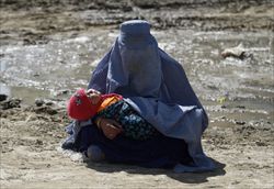 Una donna con il burqa mendica per le strade di Kabul (foto Reuters).