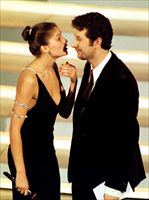 Fabio Fazio con Laetitia Casta durante il Festival di Sanremo del 1999 (foto Ansa; foto di copertina: Reuters).