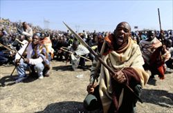 I minatori sudafricani della Lonmin in protesta con lance e armi tradizionali (Ansa).