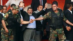 Il presidente Mohammed Morsi protetto dalle guardie del corpo (foto del servizio: Reuters).