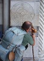 Un pellegrino in cammino sulla via Francigena, si ferma ad osservare un labirinto presso la chiesa di San Martino di Lucca.