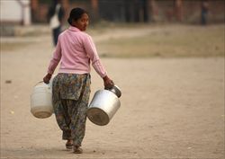 Una donna torna a casa senz'acqua per limiti nell'approvvigionamento a Katmandu, nel Nepal (Reuters)