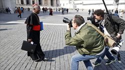 Il cardinale Arinze assediato dai fotografi in piazza San Pietro (foto del servizio: Reuters).