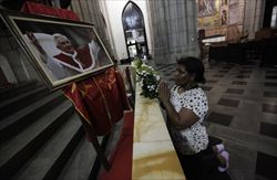 Una donna brasiliana prega davanti all'immagine di Benedetto XVI nella cattedrale di San Paolo (Reuters).