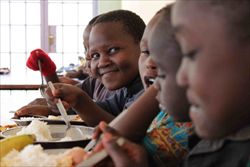 Un gruppo di bambini pranza al "Villaggio dei Ragazzi" di Amref, a Nairobi (Foto: Amref).