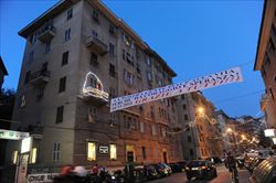 Via Fereggiano, la strada di Genova più colpita dall'alluvione, con le illuminazione natalizie (foto Ansa).