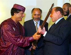Gheddafi regala a Berlusconi un vecchio moschetto sottratto agli italiani in epoca coloniale. E' un dono, in segno d'amicizia, dice il leader libico. E' il 28 ottobre 2002 (foto Ansa/Filippo Monteforte), 