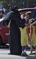 Una donna con il niqab a passeggio con le figlie a Place de la Concorde, Parigi.