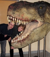 I due curatori della mostra si affacciano dal morso del Tirannosauro.