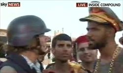 Un fermo immagine tratto da un video di Skynews che mostra uno dei ribelli all'interno del compound del colonnello  Gheddafi con un cappello e una collana presi dentro le stanze del dittatore libico.