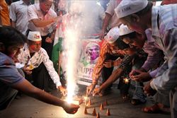 Alcuni sostenitori dell'attivista indiano della non-violenza Anna Hazare festeggiano con i fuochi d'artificio a Calcutta.