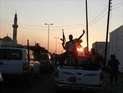 Ribelli esultano dopo la presa di Bab al-Aziziya, il compound di Muammar Gheddafi, Tripoli, lo scorso 23 agosto.