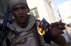 Un giovane brucia una fotografia di Gheddafi durante la battaglia per il controllo di Abu Salim, un quartiere di Tripoli.