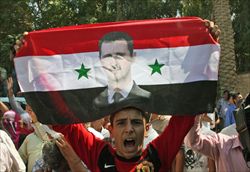 Un siriano manifesta in favore del presidente Bashar el Assad nella città di Deir el-Zour.