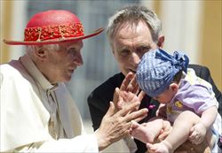 Papa Benedetto XVI con un bambino. Foto Ansa.