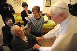 Papa Benedetto XVI visita un'anziana nella casa della Comunità di Sant'Egidio (Reuters).