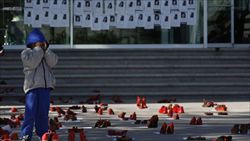 A Ciuda juarez, le scarpe rosse e i volti sui manifestini ricordano le vittime della violenza (Reuters).