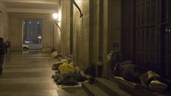 Un gruppo di senzatetto cerca rifugio sotto il colonnato di San Pietro, a Roma (foto Ansa).