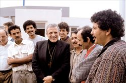 Don Tonino Bello con un gruppo di immigrati che aveva accolto in Chiesa.
