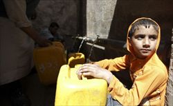 Un ragazzo riempie un contenitore d'acqua potabile a Saana, la capitale dello Yemen. Foto Reuters. 