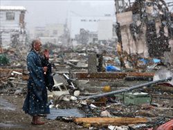 Un monaco buddista giapponese prega per le vittime nella città di Yamada, devastata dallo tsunami (foto Ansa).