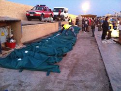 I corpi degli immigrati morti nella traversata del Canale di Sicilia sul molo di Lampedusa (Ansa).