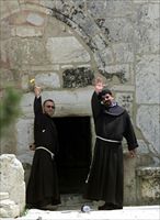 Padre Ibrahim Faltas (a destra) con un confratello sulla soglia della Basilica della Natività nel 2002,durante l'assedio (foto Reuters).