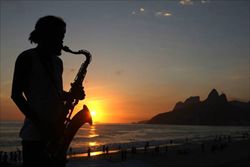 Un musicista sulla spiaggia di Rio de Janeiro (Ansa). 