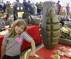 Sabrina Martin, 7 anni, davanti alla gigantesca riproduzione di una bomba a mano durante un "gun show" a West Point, nel Kentucky (Reuters).