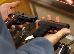 Un cliente confronta due pistole prima dell'acquisto al Gun Club di Scottsdale, Arizona (Reuters).
