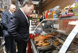 Il primo ministro russo Medvedev "controlla" la qualità delle merci in un negozio.