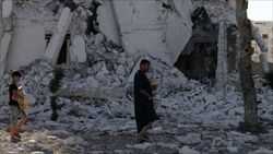 Abitanti di Aleppo (Siria) portano a casa il pane tra le macerie dei palazzi distrutti (foto Reuters).