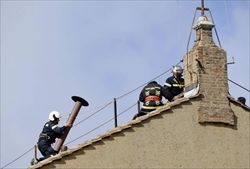 Da lì uscirà il fumo che annuncerà al mondo se il Papa è eletto oppure no: viene montato il comignolo sul tetto della Cappella Sistina. Foto Reuters. 