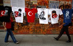 Giovani passeggiano vicino ad alcune T-Shirt appese: su di esse, l'immagine di Mustafa Kemal Ataturk, fondatore della Turchia Moderna (foto Reuters)